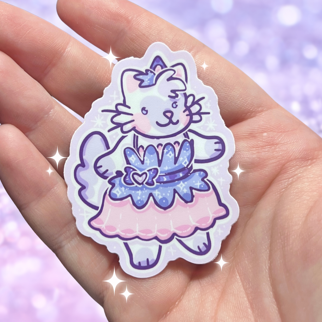 Sticker of a cat in a pink dress held in a hand with a purple glittery background