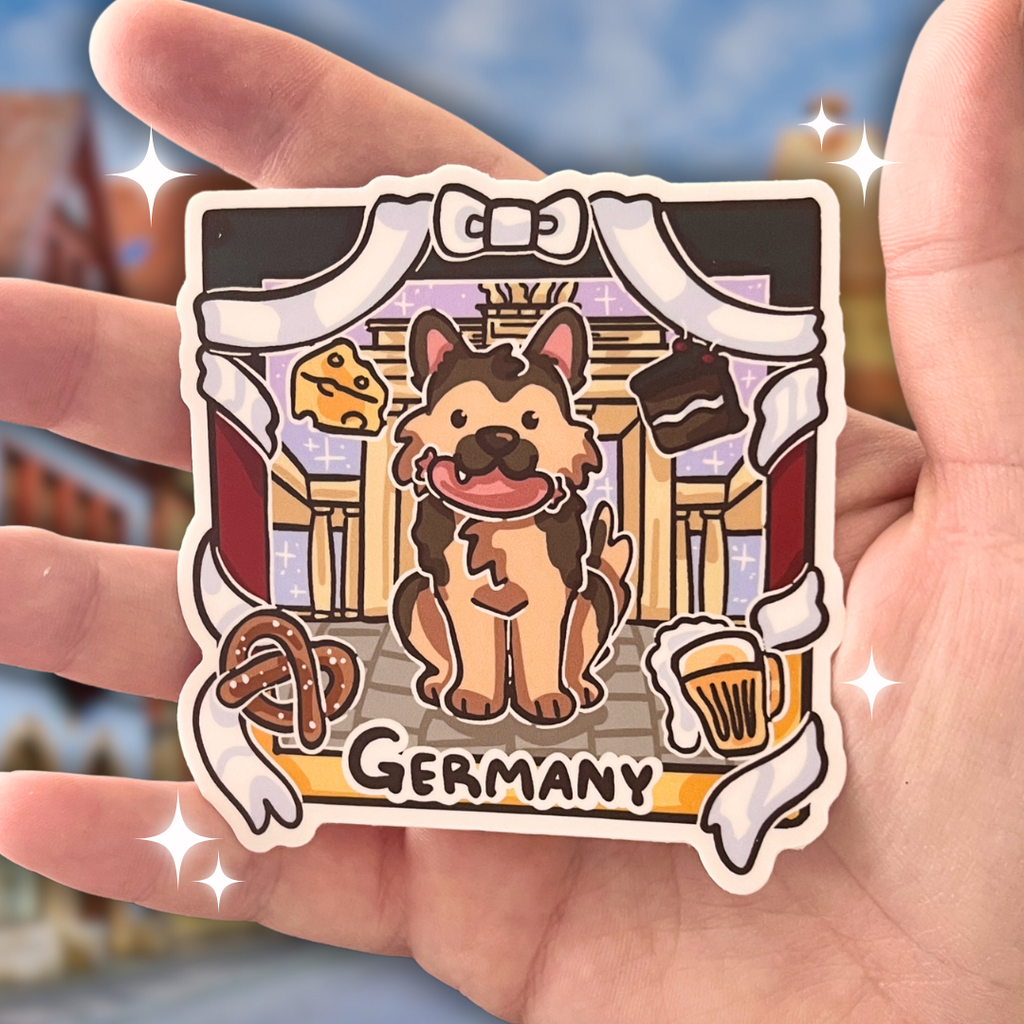 Sticker of a dog in front of the Berlin Brandenburg Gate text that says "germany" held in a hand.