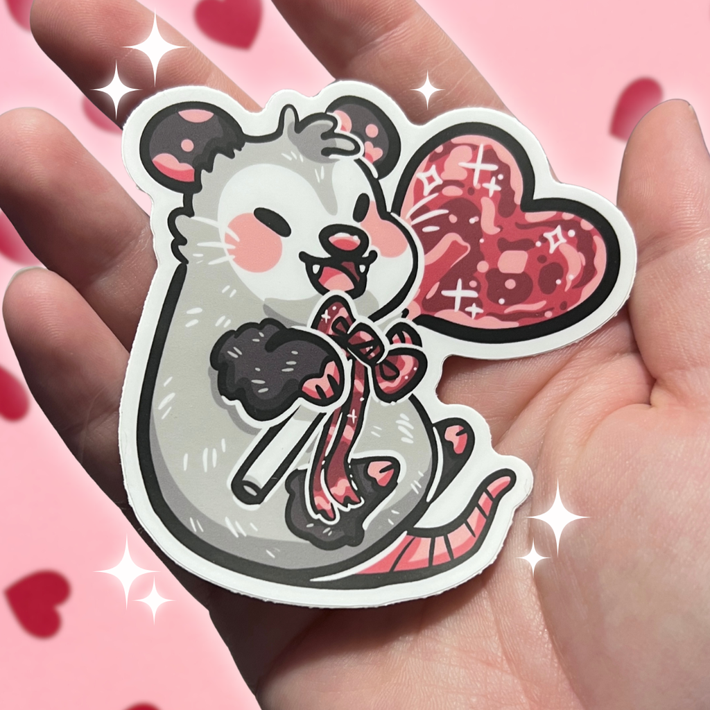 Sticker of a cartoon opossum with a lollipop held in a hand against a pink background with hearts.