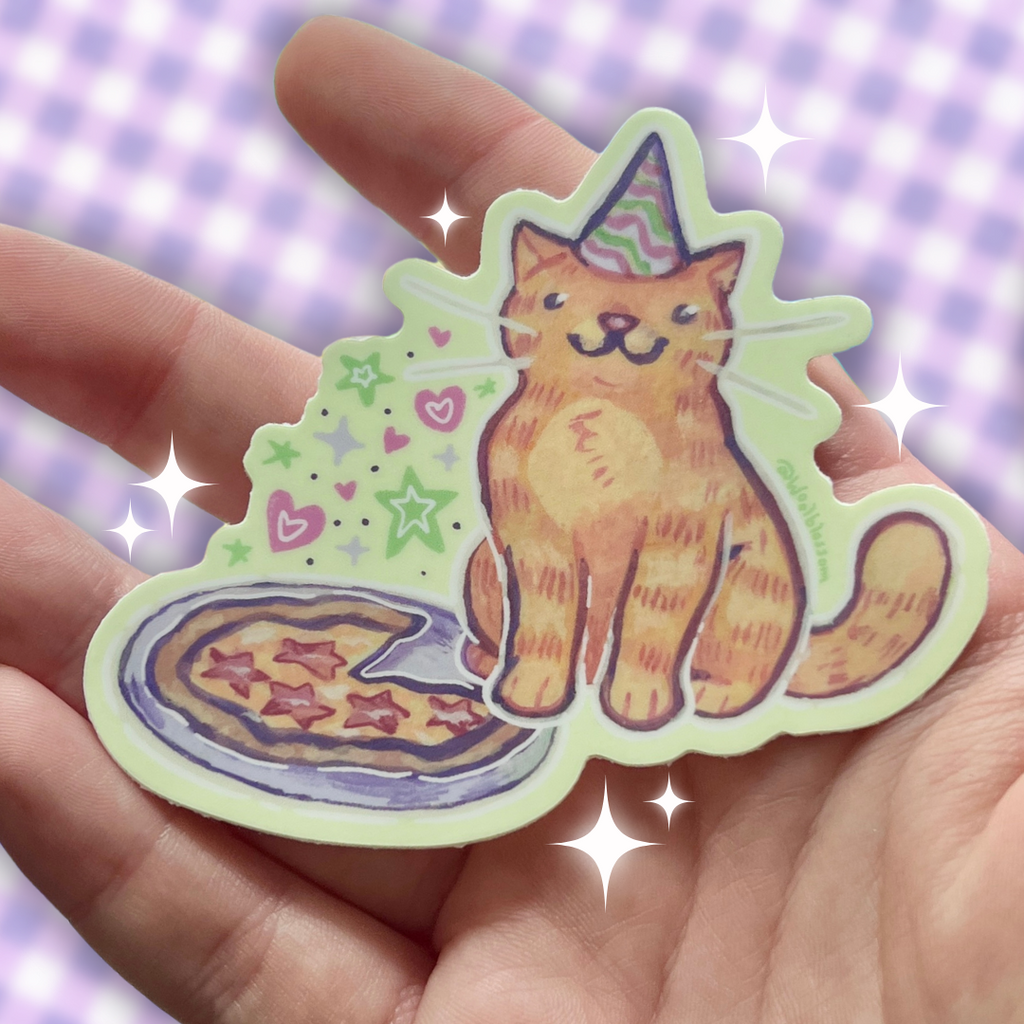 Hand holding a sticker of a cat with a party hat