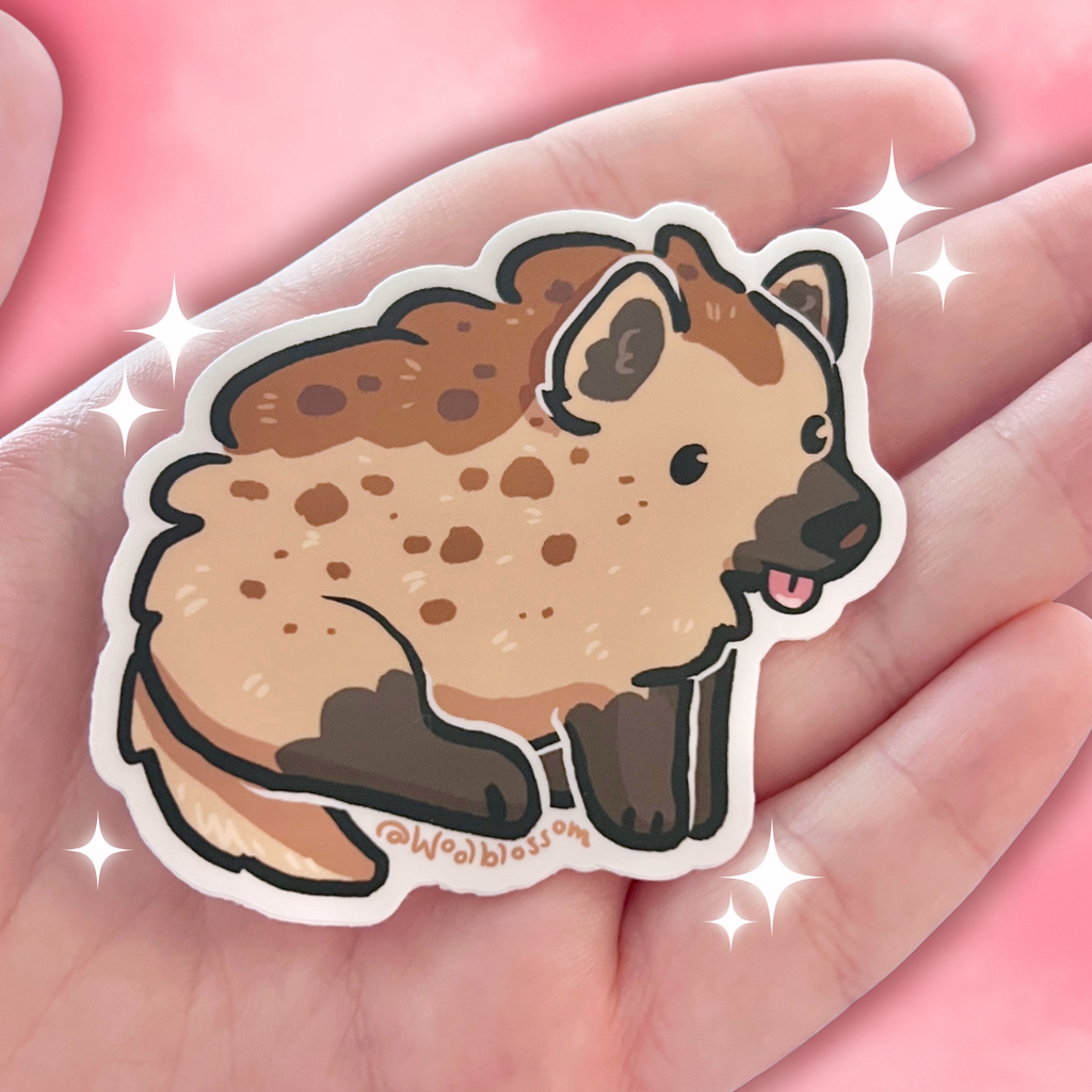 Cartoon hyena sticker held in a hand with a pink background