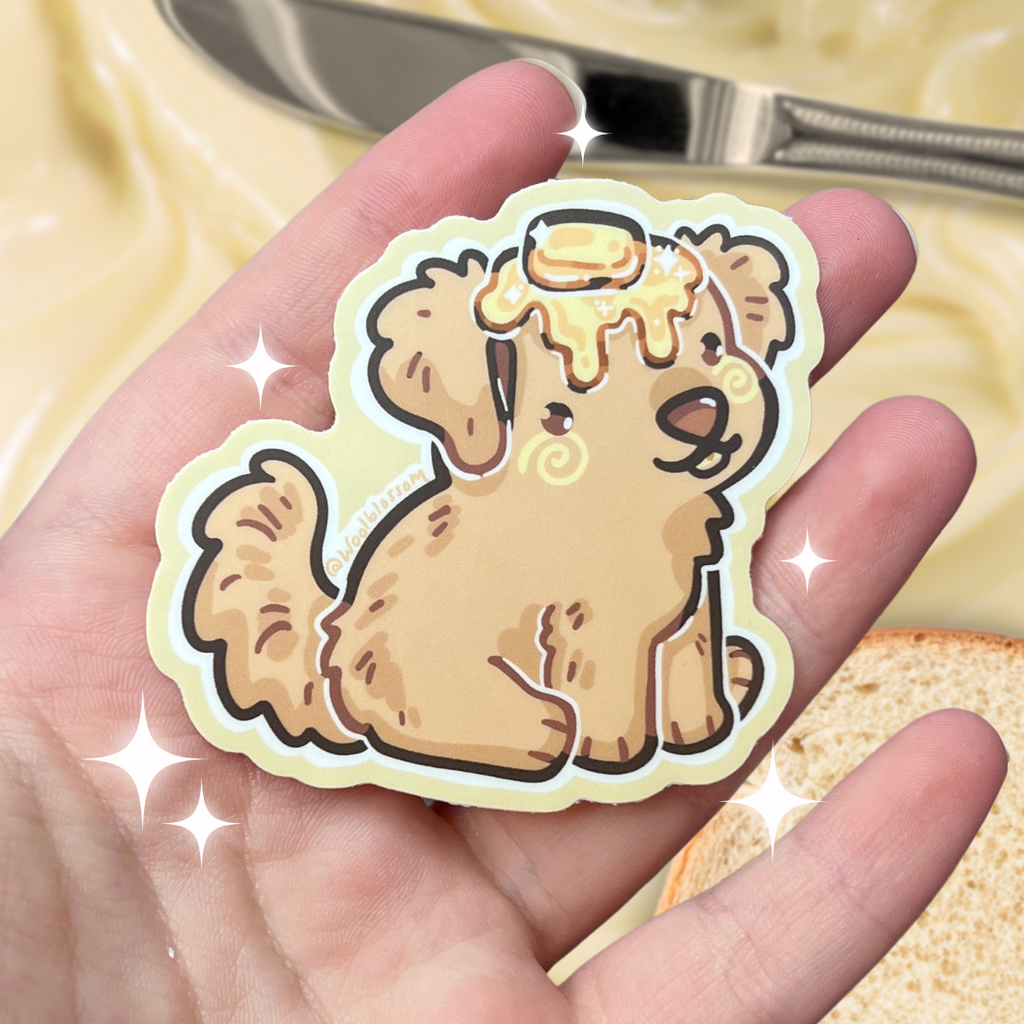 A sticker of a golden retriever puppy with butter on its head